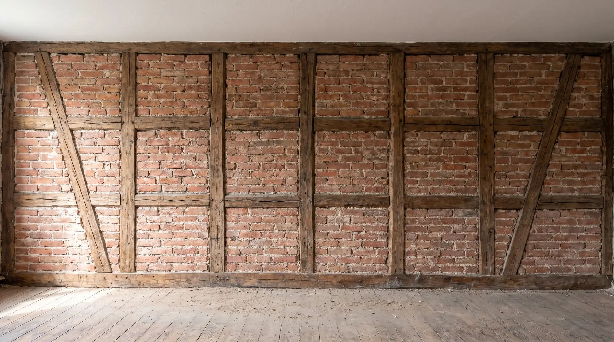 KI-Bild: Dieselbe Wand bis auf Fachwerk und Ziegel freigelegt
